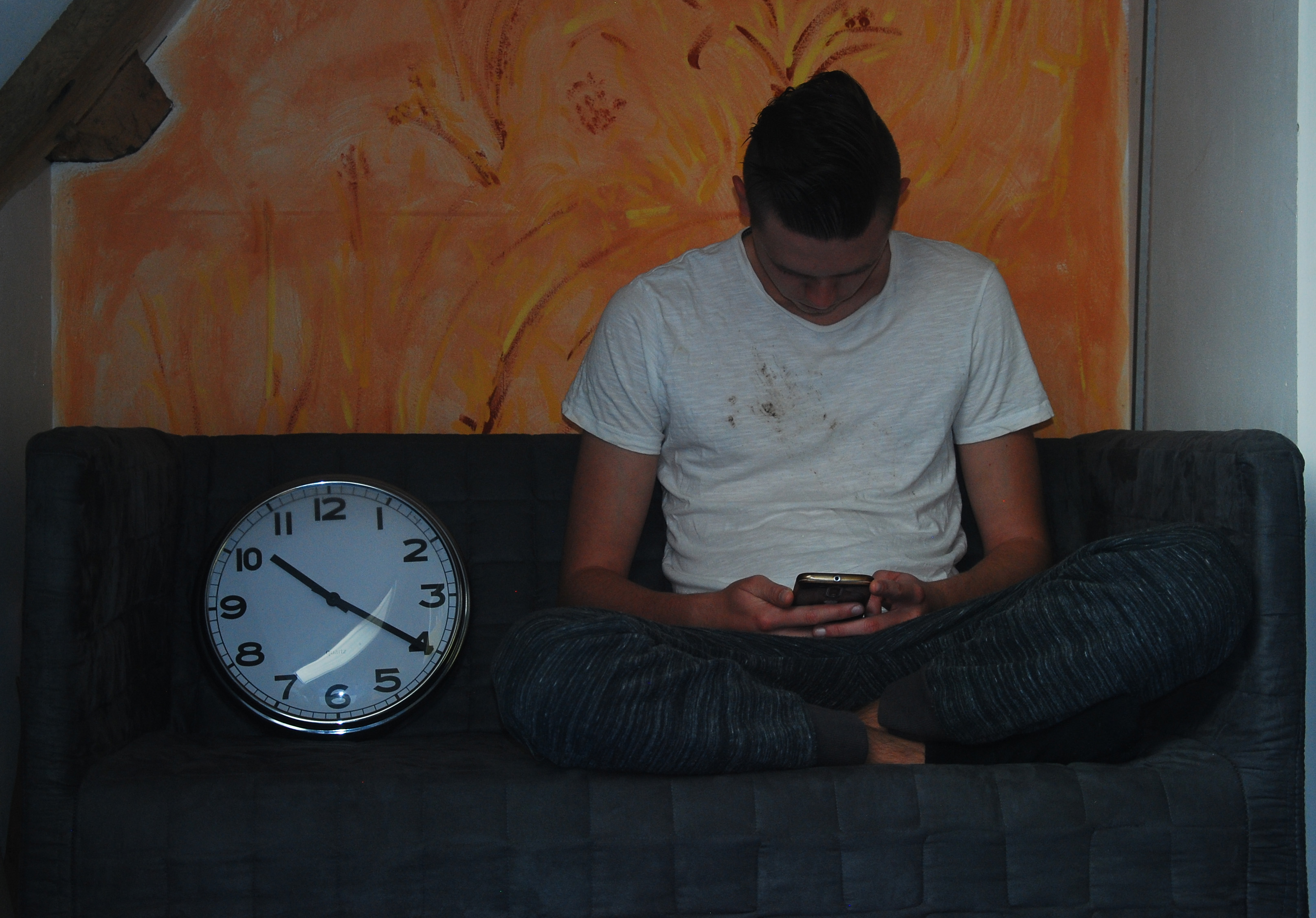 Jongen kijkt op smartphone en kijkt neutraal