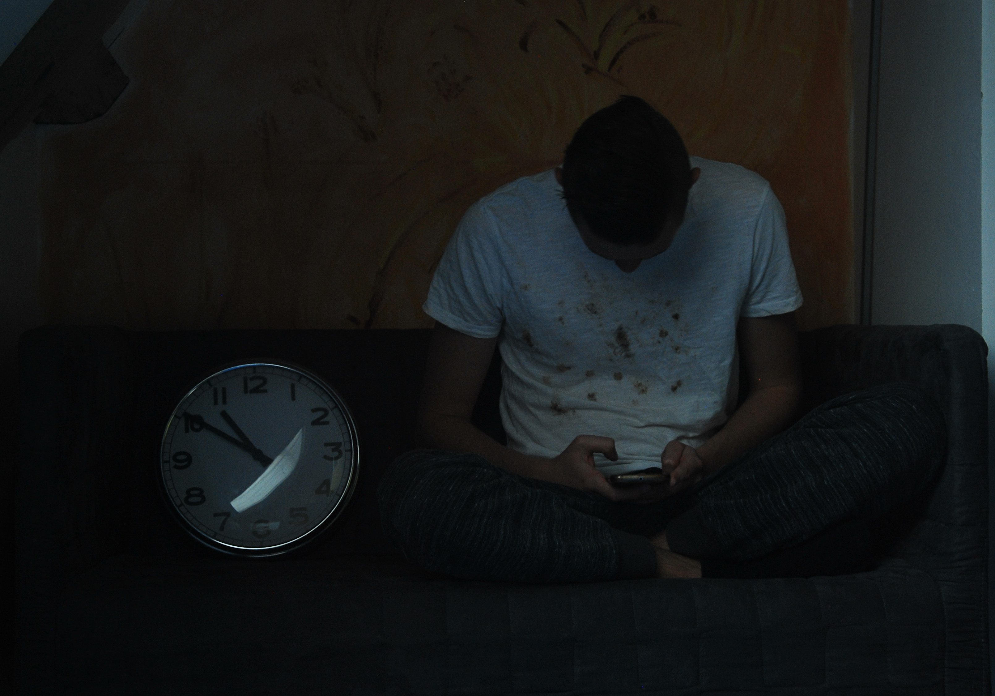 Jongen kijkt op smartphone met slechte houding en gehypnotiseerde blik