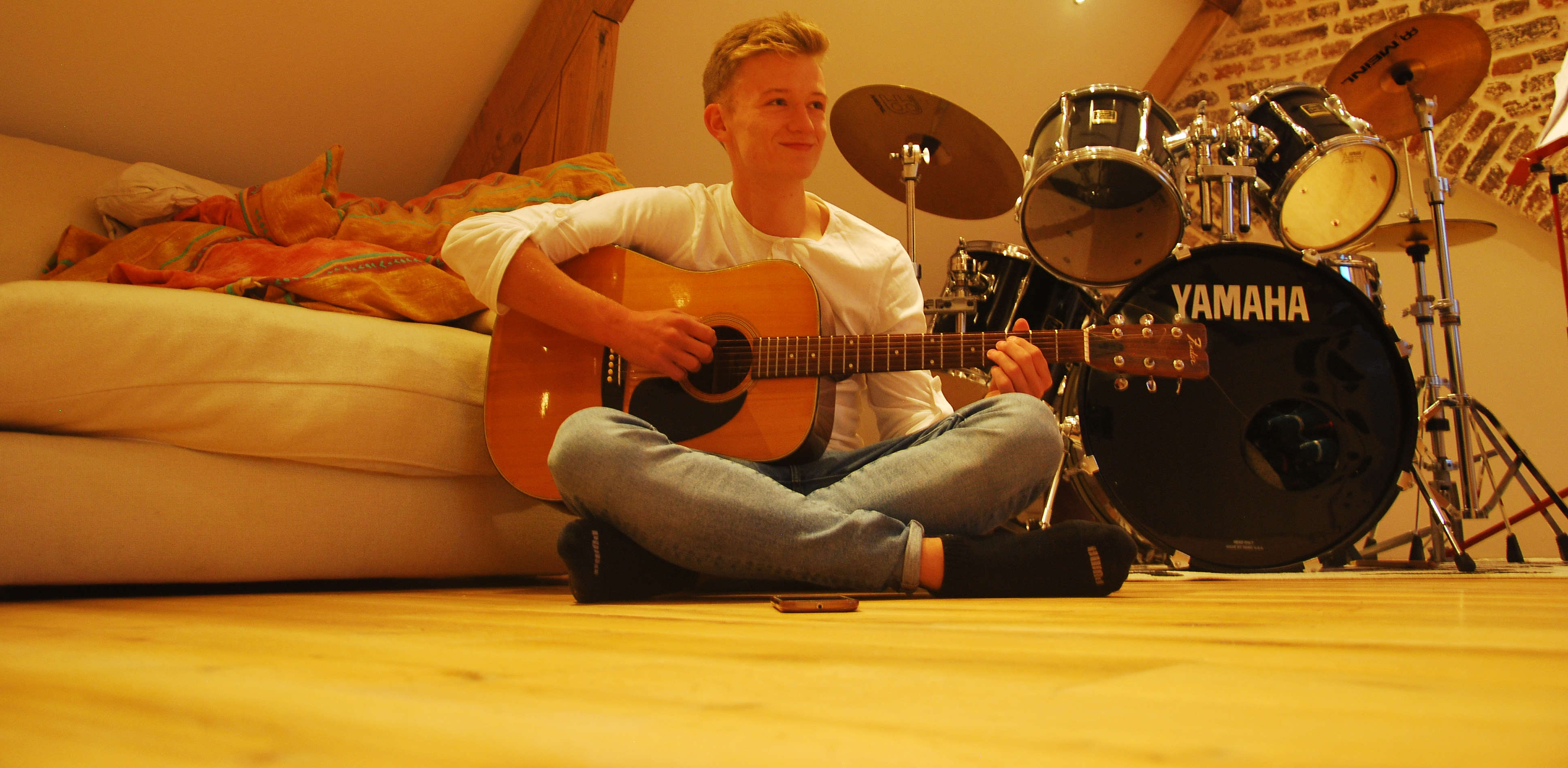 Een gitaar spelende jongen die glimlacht
